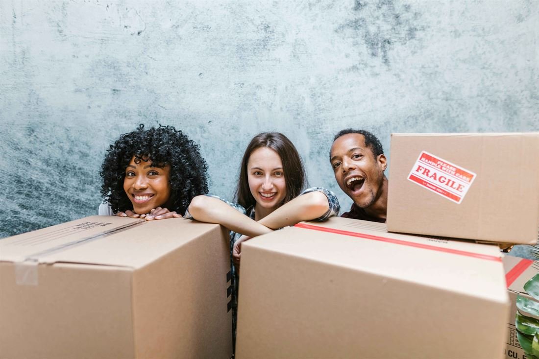 Happy customers behind moving boxes after a small apartment move in Ottawa